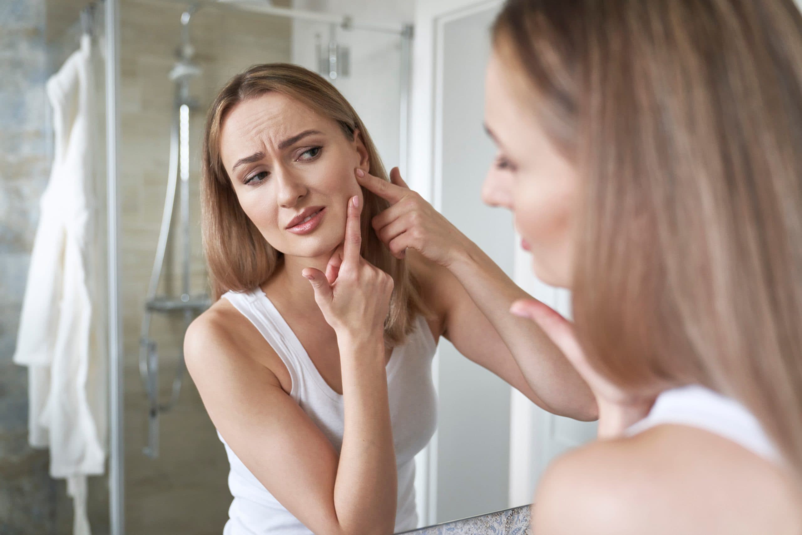 femme regarde sa peau avant utilisation appareil anti acné