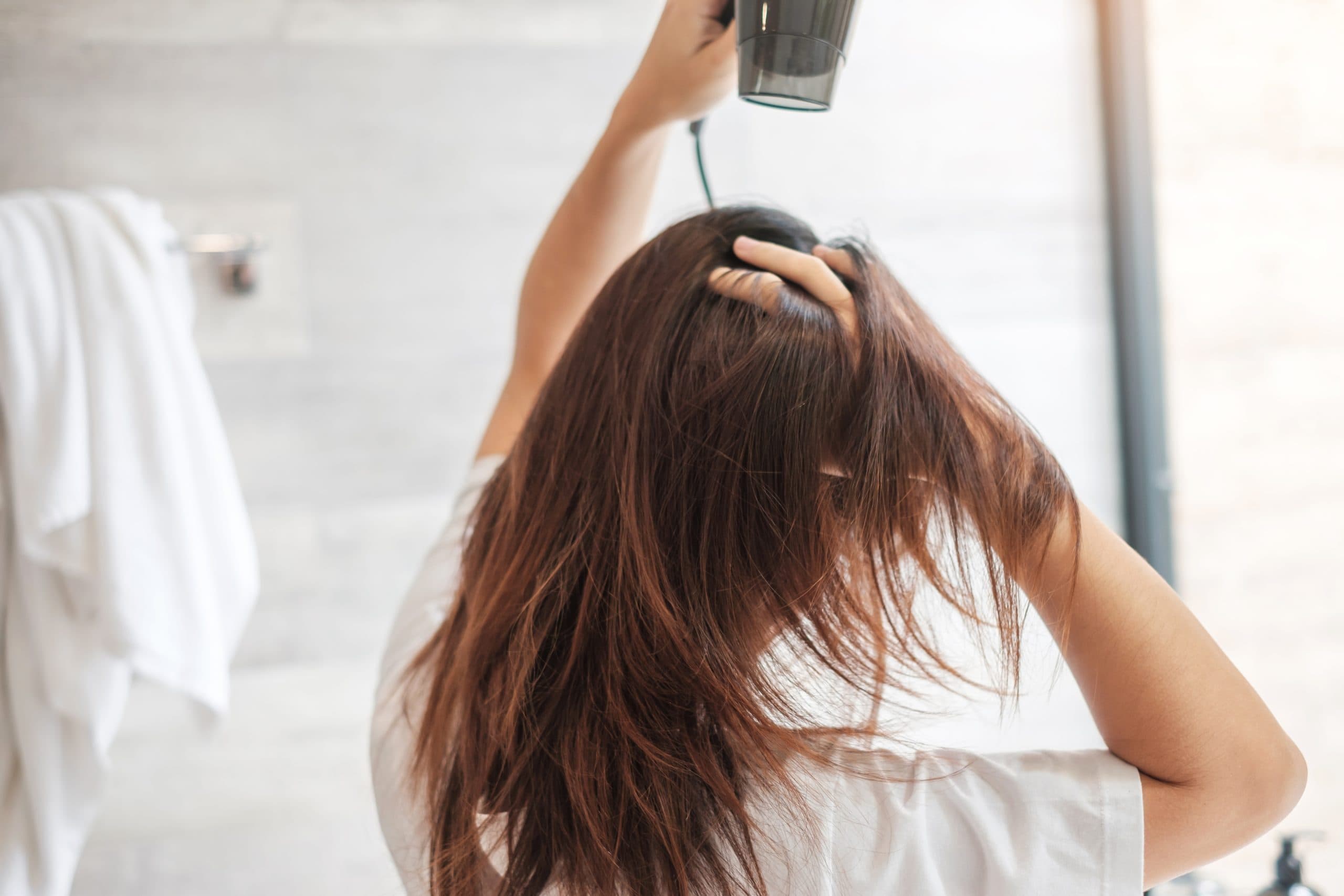 Jeune femme utilisant un diffuseur cheveux